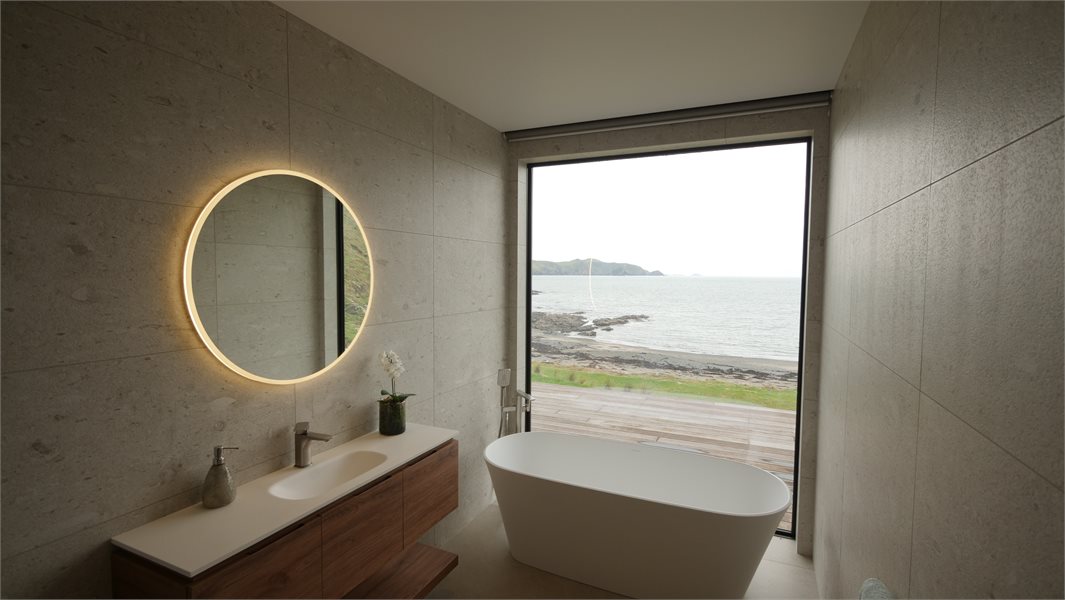 modern bathroom with picture window overlooking coastal views